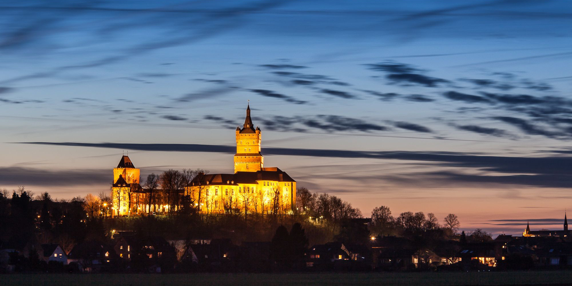 Illuminated Schwanenburg above the houses of Kleve.
