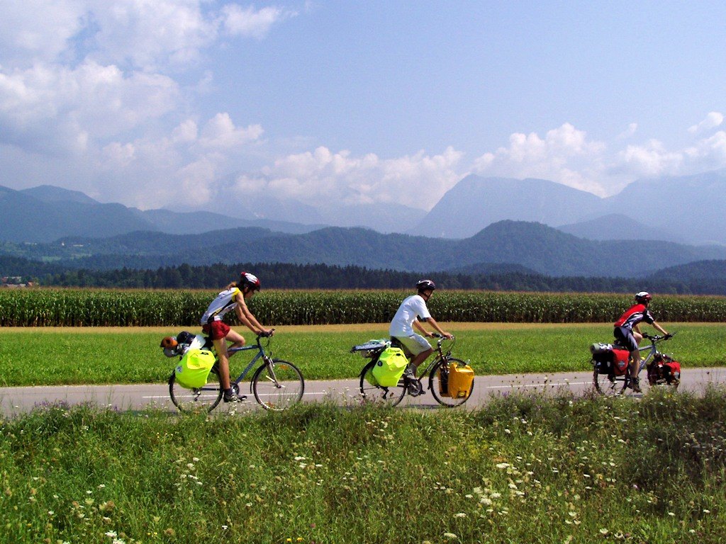 Touring cyclists against a landscape in Slovenia, illustrating how surroundings contribute to a photograph.